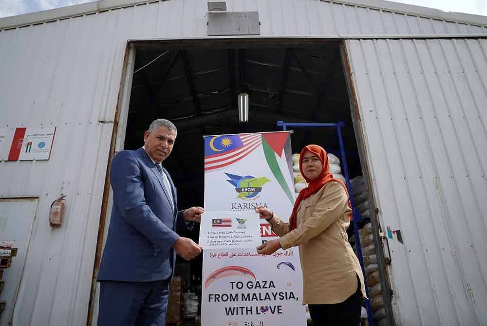 Nik Marina (kanan) dan Ahli Lembaga Pengarah Tabung Hashimiyah untuk Pembangunan Badia Jordan dan Presiden Childcare Charity Association (CCCA) Farea Al Masaiee bergambar di hadapan gudang barangan bantuan di Zarqa di sini baru-baru ini. - Foto: Bernama