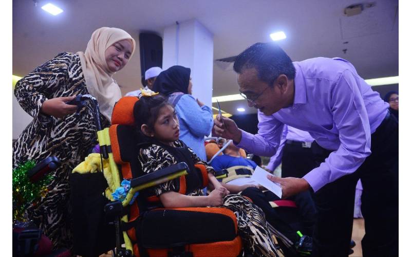Mohammed menyantuni anak-anak istimewa iaitu penghidap 'Cerebral Palsy' selepas program Ziarah Ramadan Anak Istimewa di Kompleks Kumpulan Media Karangkraf, di sini pada Khamis.