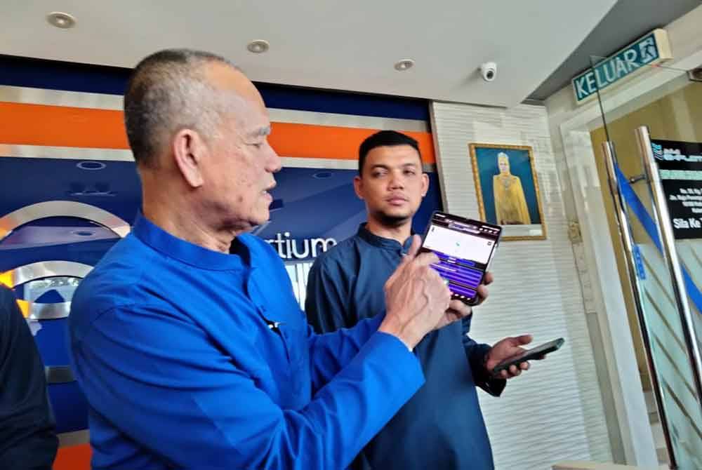 Che Ibrahim menunjukkan lokasi bas selepas mengimbas kod QR di tiket yang dibeli.