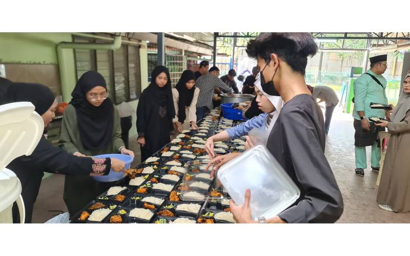 Sukarelawan sedang membungkus nasi minyak, kari kambing untuk persediaan berbuka puasa.
