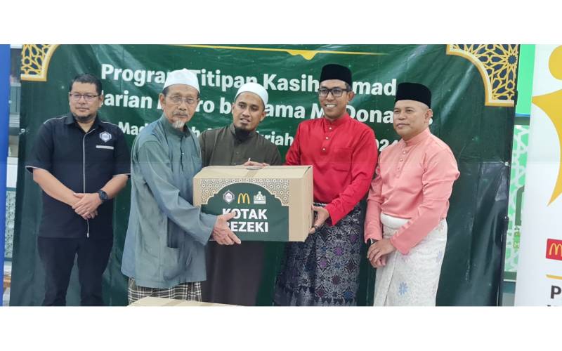 Zaid (dua dari kanan) menyerahkan Kotak Rezeki kepada komuniti Kampung Pasir Baru, Pantai Dalam, Kuala Lumpur.
