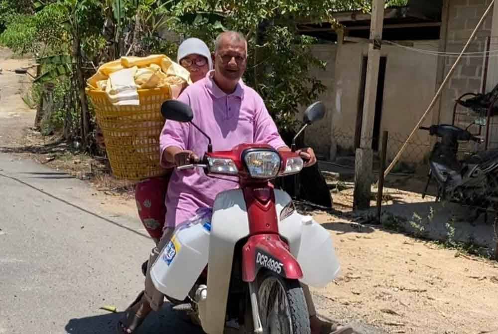 Halimah dan suami terpaksa berulang alik menaiki motosikal membawa botol untuk memunggah air.