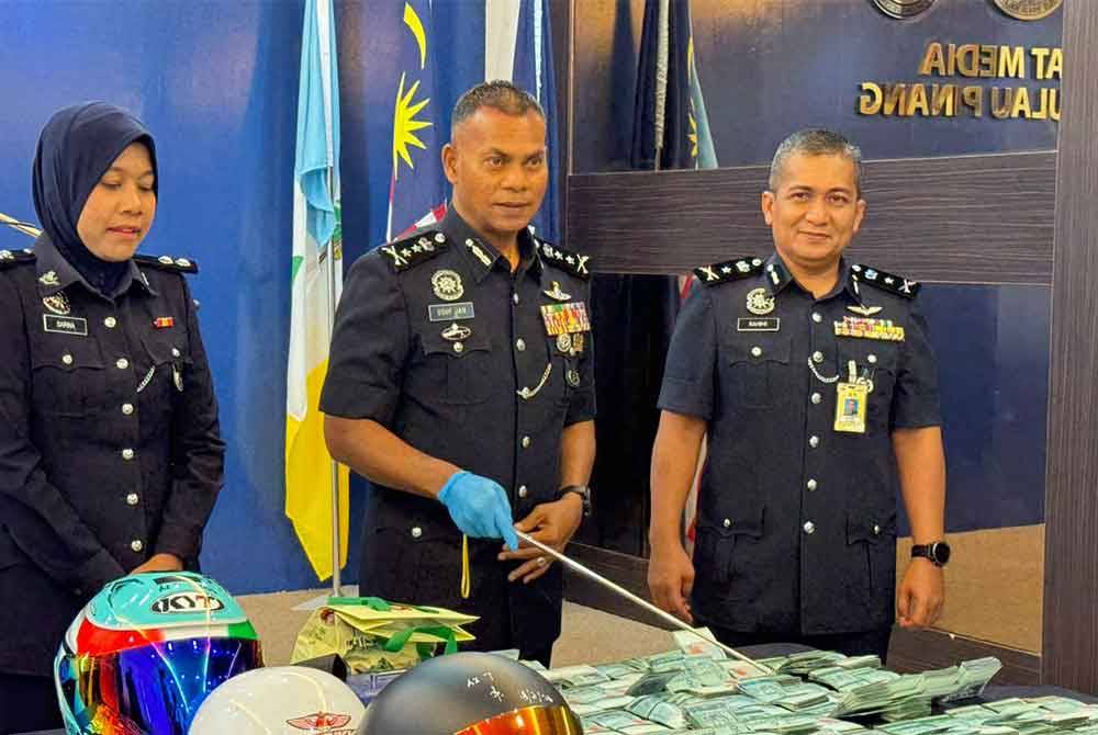 Mohamed Usuf (tengah) menunjukkan wang tunai yang berjaya ditemui semula daripada suspek.