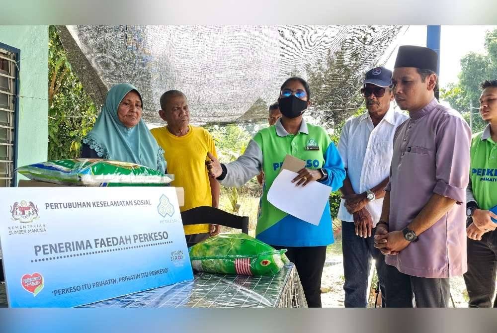 Mageswari (tengah) bersama Mohd Azlan Helmi menyampaikan sumbangan kepada Noor Asmah sebagai penerima faedah PERKESO.