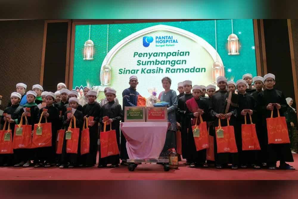 Tio Bee Chan bersama sebahagian anak yatim yang diraikan dalam Majlis Berbuka Puasa Sinar Kasih Ramadan Hospital Pantai Sungai Petani di sebuah hotel pada Jumaat.