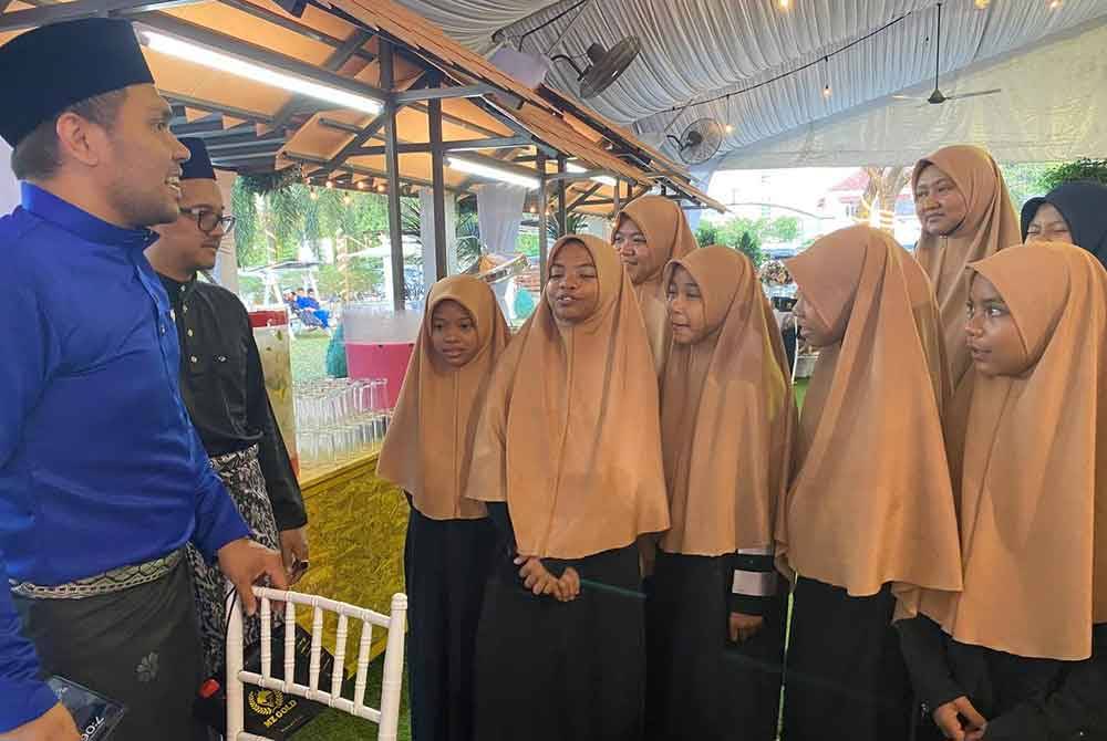 Murtadhatumizi (kiri) beramah mesra dengan anak-anak yatim semasa majlis berbuka puasa.