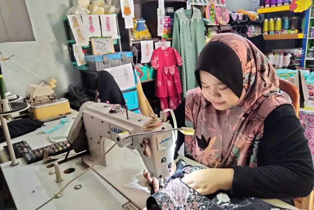 Siti Hajar Aisyah tidak menang tangan menjahit tempahan yang diterima.