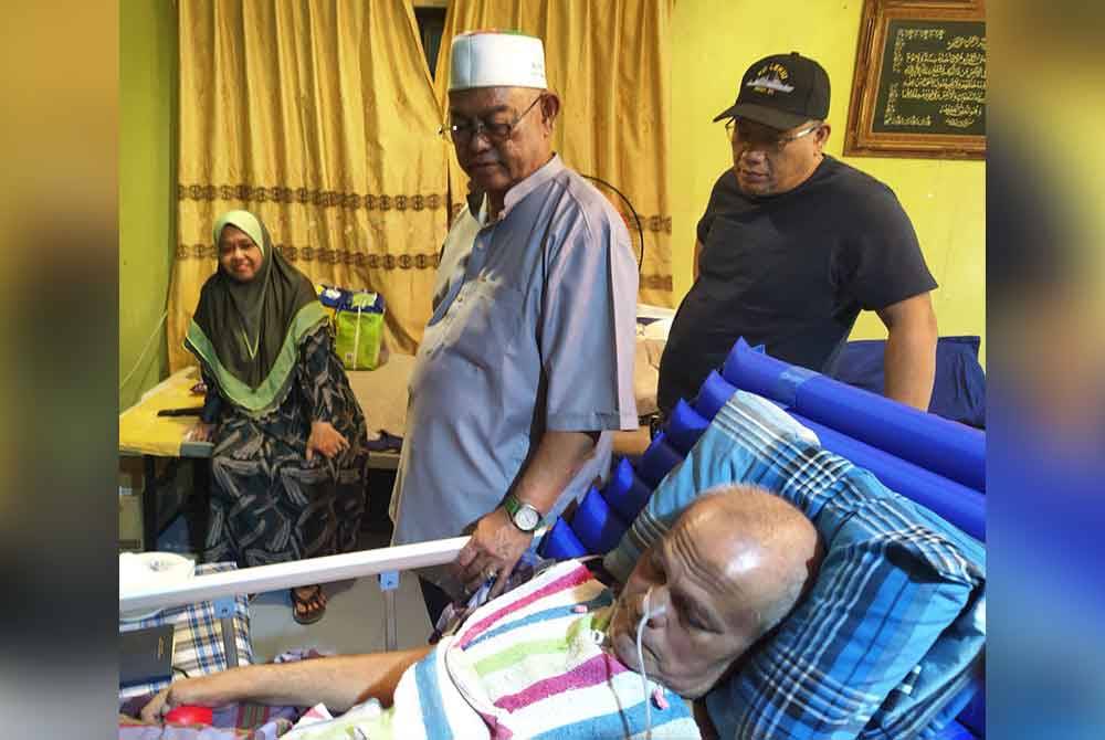 Noh (tengah) menziarahi bekas ketua kampung, Hashim Zakaria, 64, yang terlantar di rumahnya di Kampung Pinang di sini pada Sabtu.