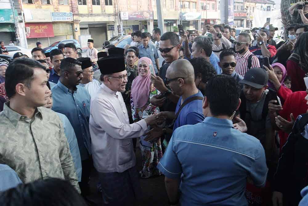 Anwar menyantuni orang ramai semasa meluangkan masa kira-kira sejam mengunjungi Bazar Ramadan Mahkota Square hari ini. Foto Bernama
