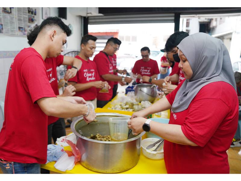 Sukarelawan program Colours of Ramadan: ‘Rewang Iftar’ sedang menyiapkan hidangan nasi Arab untuk gelandangan.