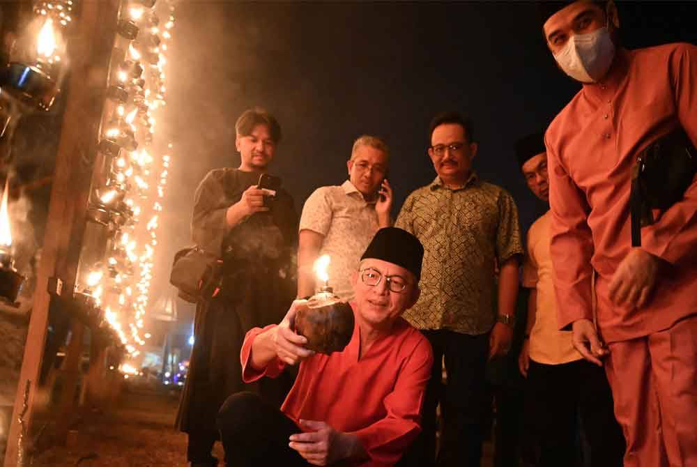 Razali (depan) menunjukkan pelita daripada tempurung kelapa yang turut dipertandingkan dalam pertandingan Pelita Raya Terengganu (Peliter @TTI). FOTO: Urusetia Penerangan Darul Iman (UPDI).