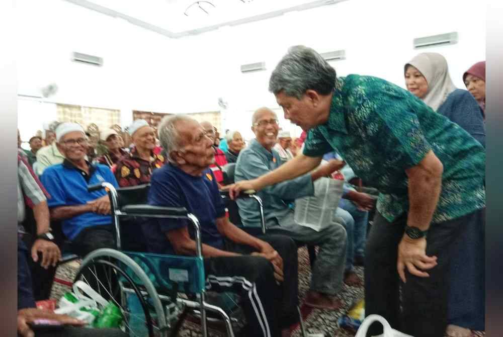 Mohamad (kanan) ketika menyampaika sumbangan tersebut.