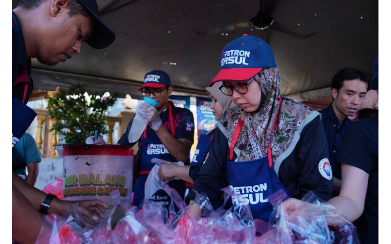 Sukarelawan Petron Malaysia sedang menyusun juadah iftar yang diberikan secara percuma kepada pengunjung di Bazar Peringgit, Melaka. 