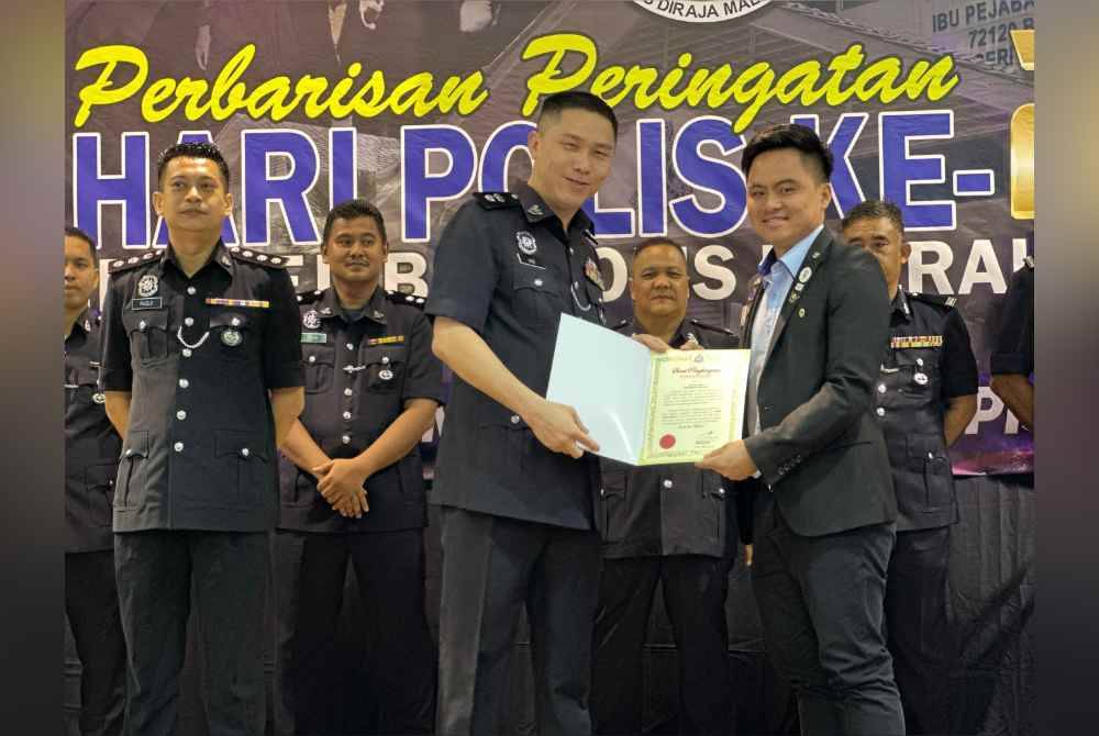 Chang Hook menyerahkan sijil penghargaan kepada orang awam pada majlis tersebut.