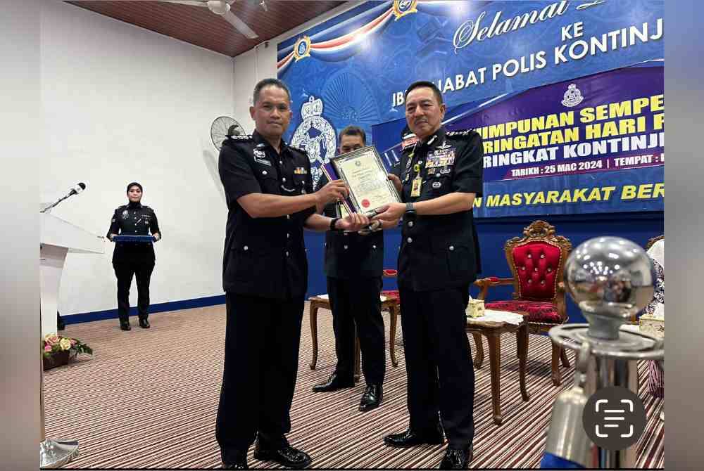 Samsuddin (kiri) menerima anugerah yang disampaikan oleh Muhamad Zaki (kanan).