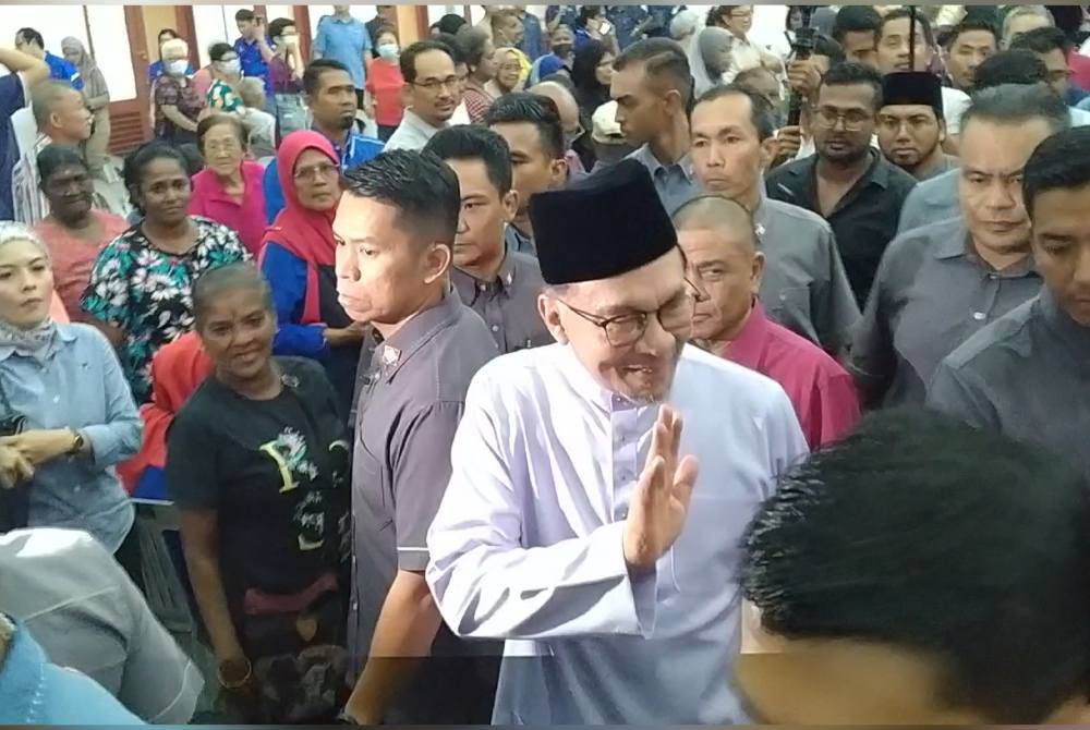Anwar (dua dari kiri) menyantuni masyarakat setempat selepas menyempurnakan Program Gerak Rahmah 2024: Jom Masak Bubur Lambuk Perpaduan dan Penyampaian Sumbangan Rahmah Parlimen Tambun di Dewan KRT Taman Meru di sini pada Isnin.