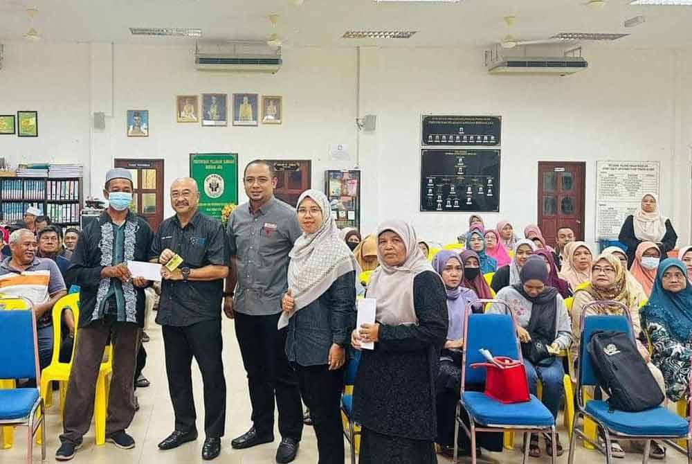 Abdul Rahman (dua dari kiri) menyampaikan sumbangan wakalah zakat kepada penerima.