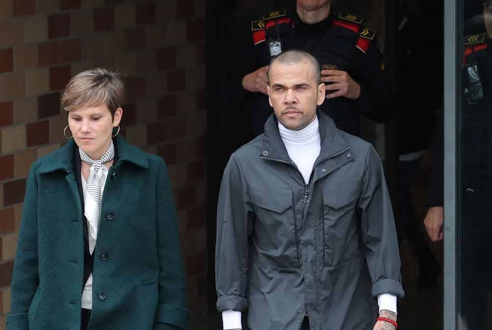 Alves (kanan) meninggalkan penjara di San Esteban, Barcelona pada Isnin. Foto AFP