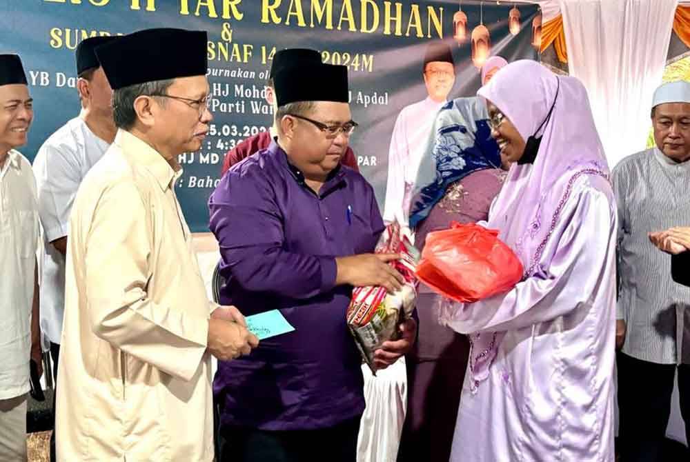 Mohd Shafie menyampaikan sumbangan kepada golongan asnaf ketika hadir Majlis Berbuka Puasa di Surau Haji Md Yamin Kampung Surapit, Papar.