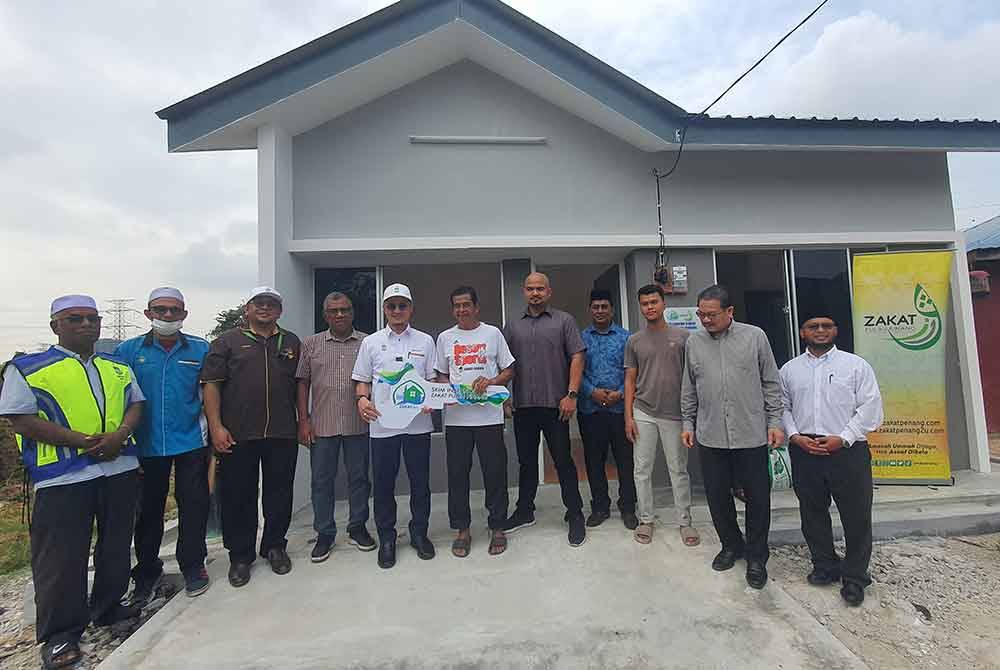 Mohamad (lima dari kiri) menyerahkan replika kunci kepada Saa'din dalam majlis yang diadakan di Seberang Jaya, pada Selasa.