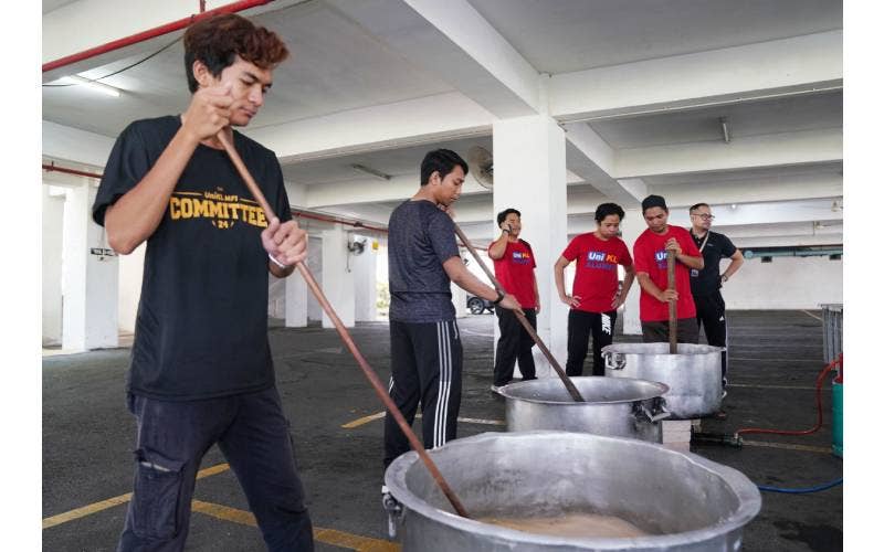 Sebahagian daripada pelajar UniKL yang begitu bersemangat mengacau bubur lambuk pada program Mega Bubur Lambuk yang dianjurkan oleh universiti berkenaan, semalam.
