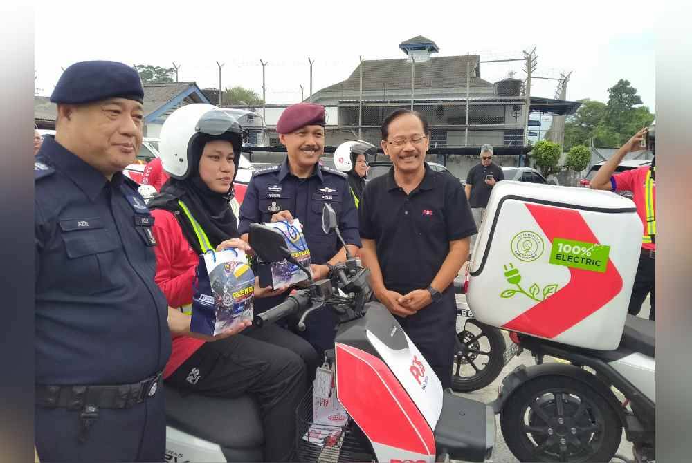 Mohd Yusri (dua dari kanan) menyampaikan cenderahati kepada kakitangan Pos Malaysia selepas menyempurnakan Majlis Pelancaran Program Pencegahan Jenayah Komersil Phone Scam - Penyamar Pos Malaysia di Ibu Pejabat Polis Kontinjen Perak di sini pada Selasa.