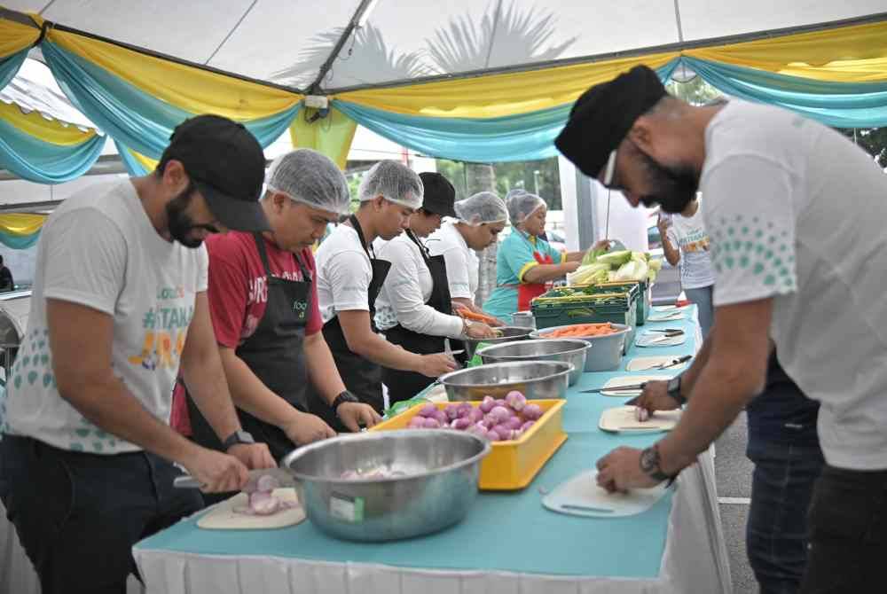 Para sukarelawan sedang menyiapkan bahan pada program #KitakanJiran Ramadan Cookout yang diadakan di Lotus's Shah Alam.