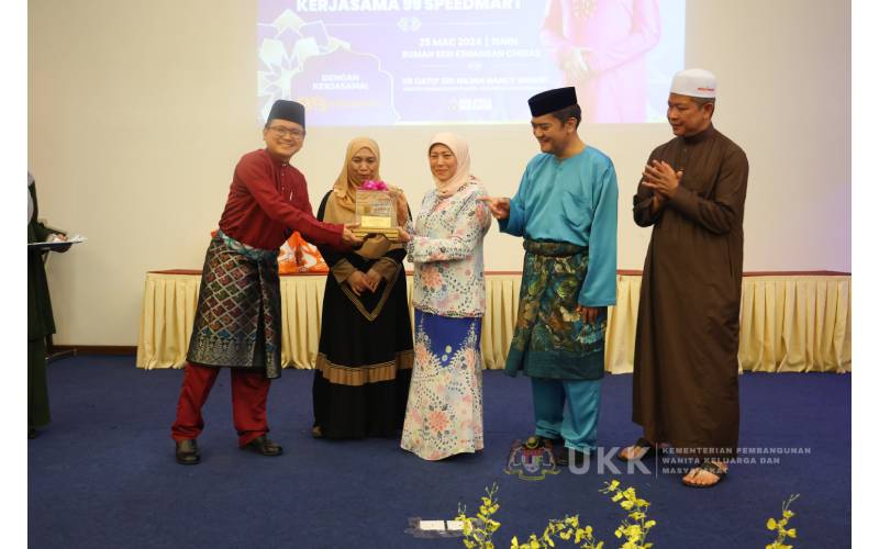 Yong Ean Kwang (kiri) menyerahkan cenderahati kepada Nancy sebagai tanda penghargaan sambil disaksikan oleh Norazman (dua dari kanan). 