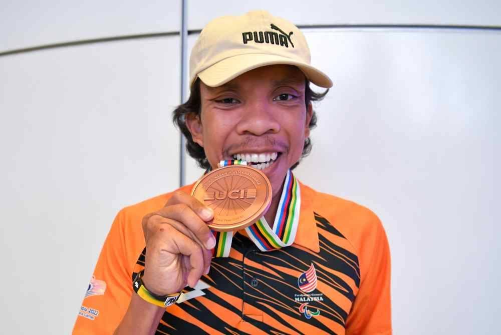 Mohamad Yusof menunjukkan pingat gangsa yang dimenangi pada UCI 2024 sejurus tiba di KLIA pada Rabu. Foto Bernama