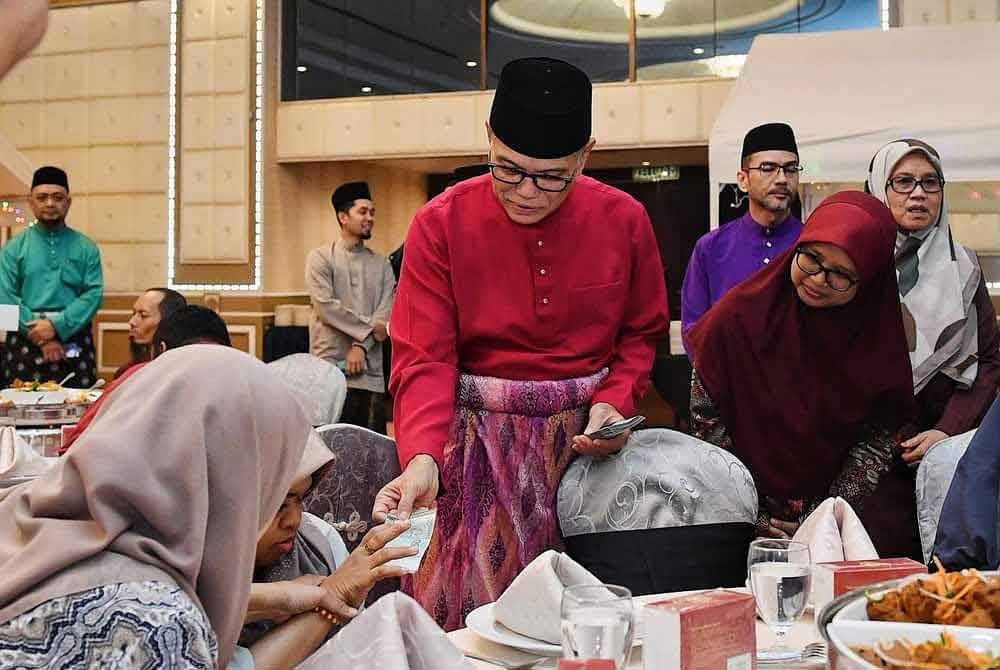 Wan Rosdy menyampaikan sumbangan kepada penerima pada Majlis Pelancaran Peringkat Kebangsaan Memacu Kehidupan Hari Raya Aidilfitri 2024 anjuran Petronas di Hotel Grand Darul Makmur pada malam Rabu.