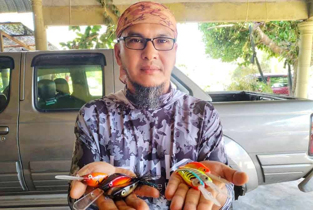Ahmad Sharul menunjukkan antara koleksi umpan tiruan menggunakan kayu pulai yang dihasilkan sendiri.