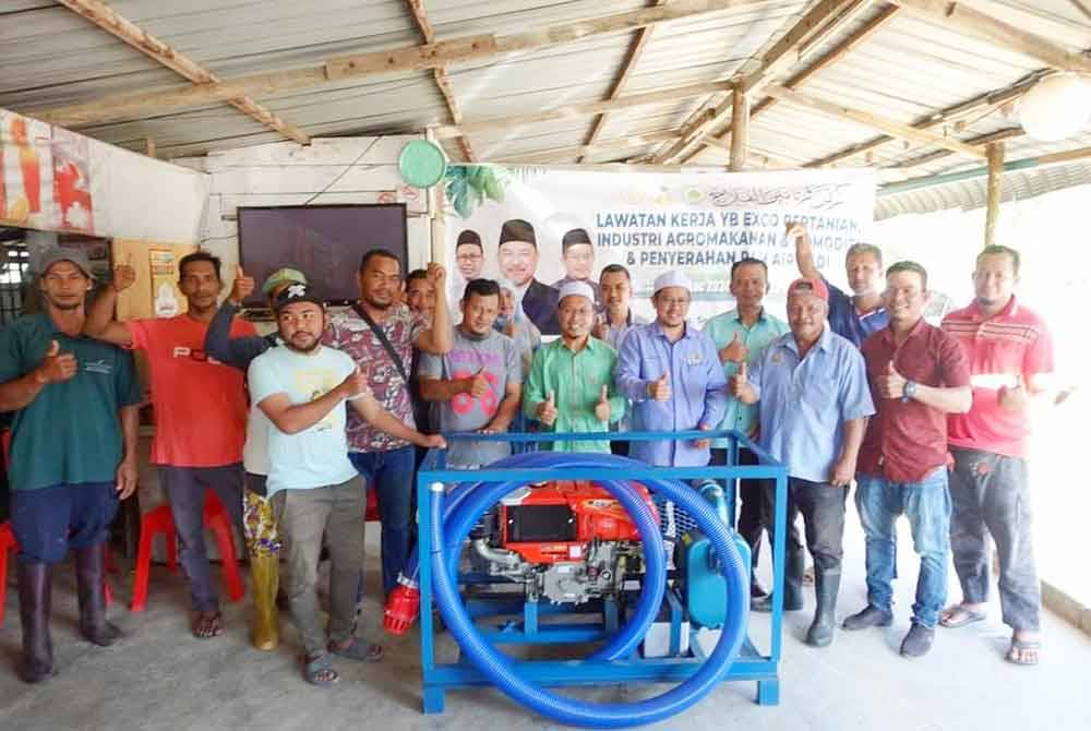Tuan Mohd Saripudin (empat dari kanan) bersama petani semasa penyerahan pam air padi di Machang.