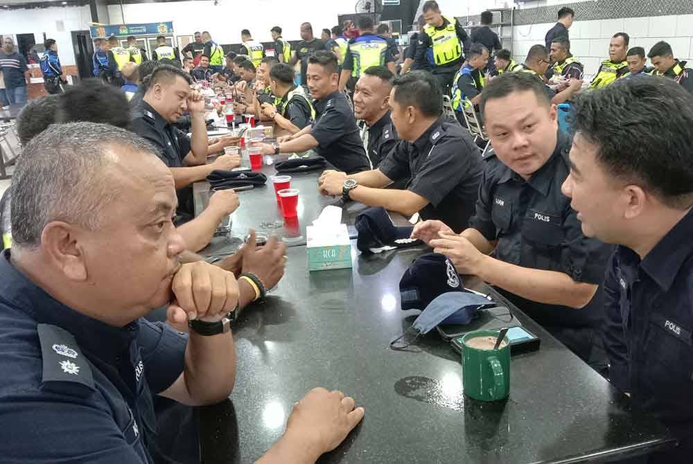 Hoong Fong (kanan) bertanyakan sesuatu kepada pegawainya ketika program singgah sahur bersama warga Ibu Pejabat Polis Daerah (IPD) Klang Selatan di Pandamaran, dekat sini pada Khamis.