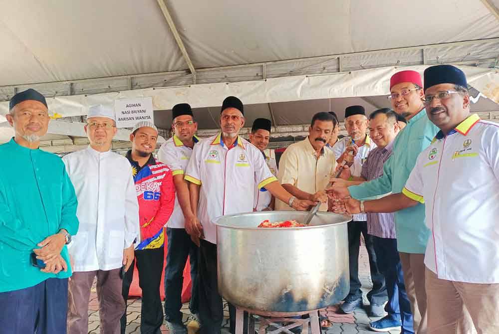 Mohamed Arib (kanan) menunjukkan hidangan nasi beriani yang siap dimasak dalam program 'Briyani Day' di Masjid Sultan Idris Shah II, Ipoh pada Khamis.