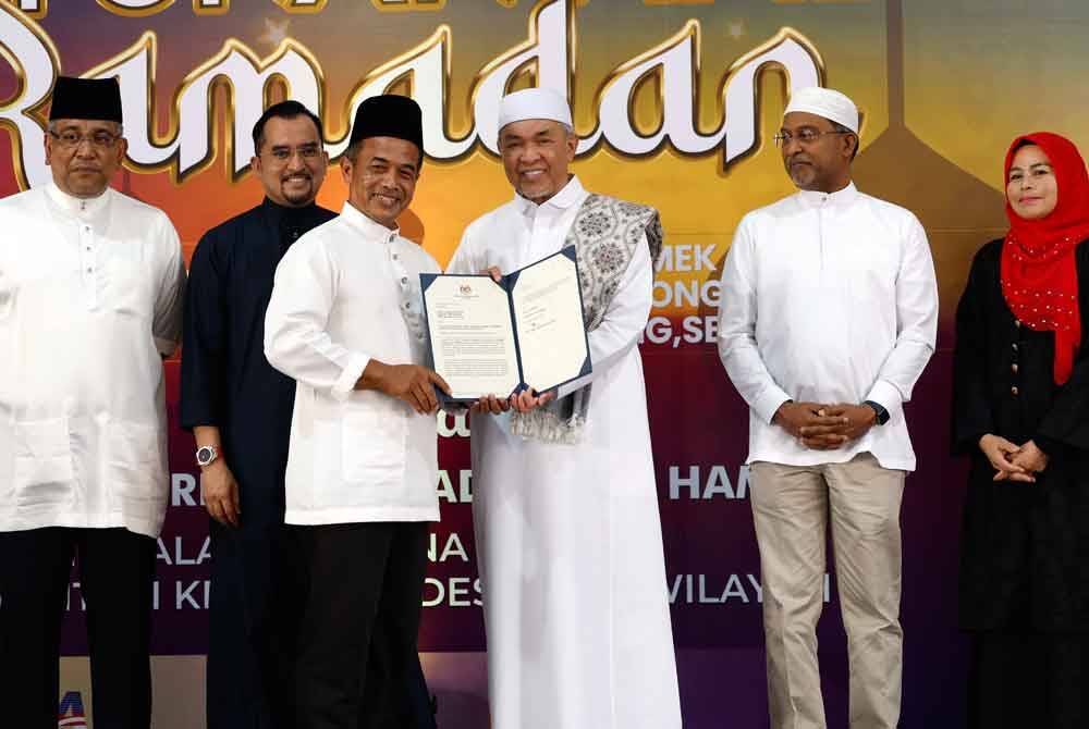 Ahmad Zahid (tiga, kanan) menyampaikan surat pelantikan pengerusi jawatankuasa penasihat peringkat Pusat Giat MARA Kuala Langat kepada Sudirman Isman. Foto Bernama