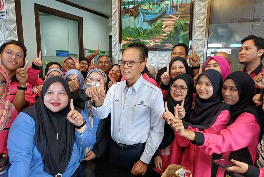 Wan Rosdy (tengah) bersama kakitangan Kosma selepas sidang akhbar pengagihan bayaran keuntungan unit saham ladang Kosma di Kuantan pada Jumaat.