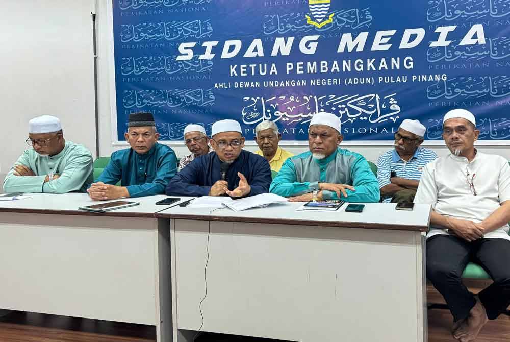 Muhammad Fauzi (tengah) mengadakan sidang akhbar di Pejabat ADUN Sungai Dua berhubung masalah pesawah pada Jumaat.