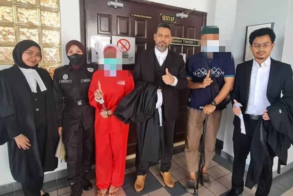 Wanita tersebut (tiga dari kiri) bersama peguam di hadapan pintu Mahkamah Tinggi Melaka pada Jumaat.