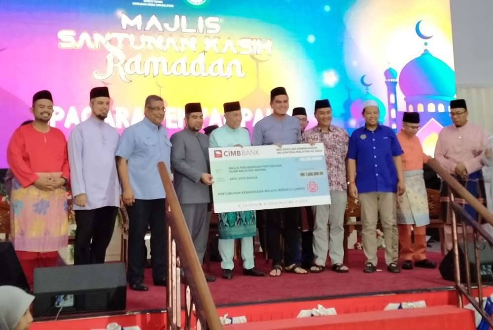 Muhamad Akmal (empat dari kanan) bersama Ahmad Zahid menyaksikan penyerahan sumbangan UMNO berjumlah RM1 juta untuk bantuan kepada rakyat Palestin kepada MAPIM sempena Majlis Santunan Kasih Ramadan di Dewan Perdana, Kompleks UMNO Bahagian Bagan Datuk di sini pada Jumaat.