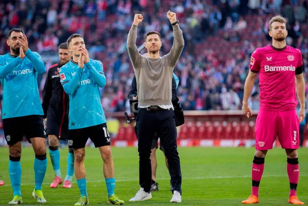 Alonso (tengah) memimpin Leverkusen menerajui Bundesliga dengan perbezaan 10 mata ke atas Bayern di tempat kedua.