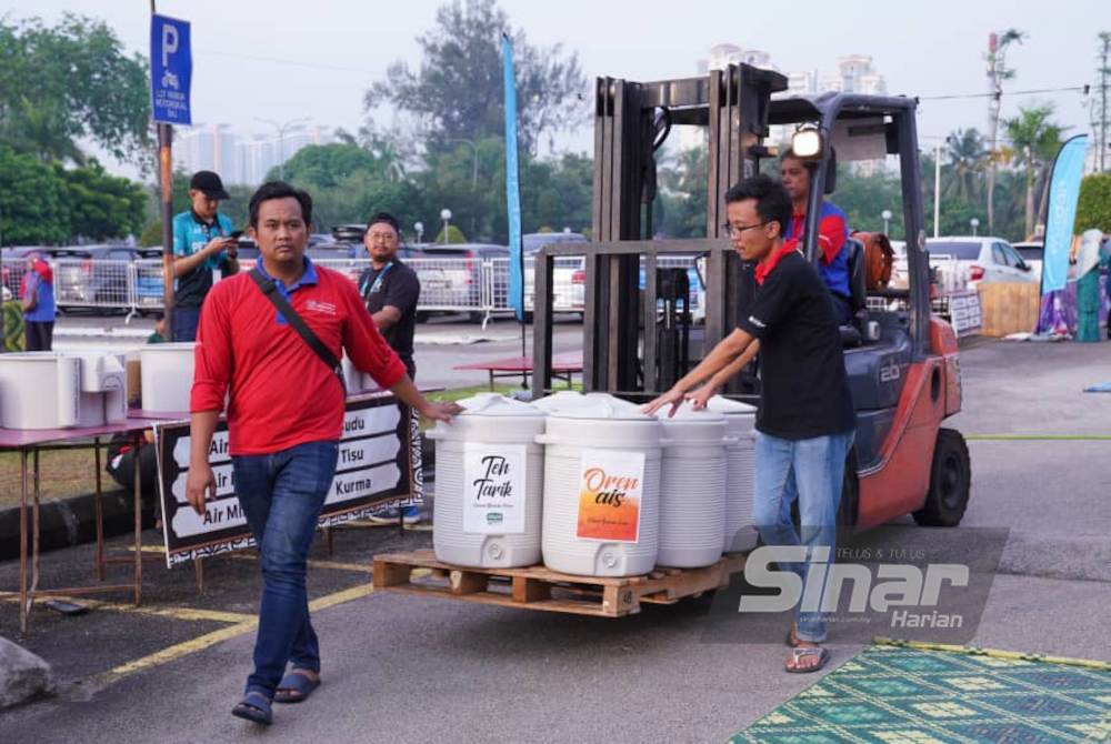Petugas Iftar Ala Madinah membawa bekas minuman untuk disusun di atas meja bagi memudahkan pengunjung. Foto Sinar Harian-Rosli Talib dan Mohd Halim Abdul Wahid