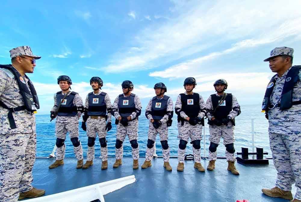 Amiludin (kiri) memberi taklimat kepada anggota sebelum operasi dimulakan.