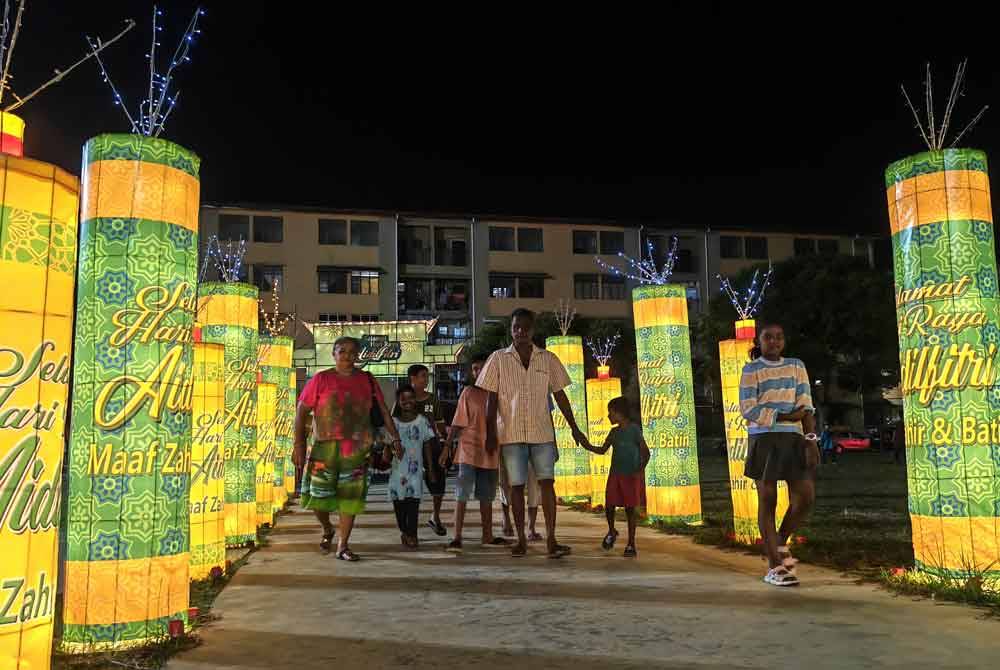 Masyarakat berbilang kaum berkunjung ke Dataran Lobak melihat hiasan lampu bertemakan Aidilfitri.