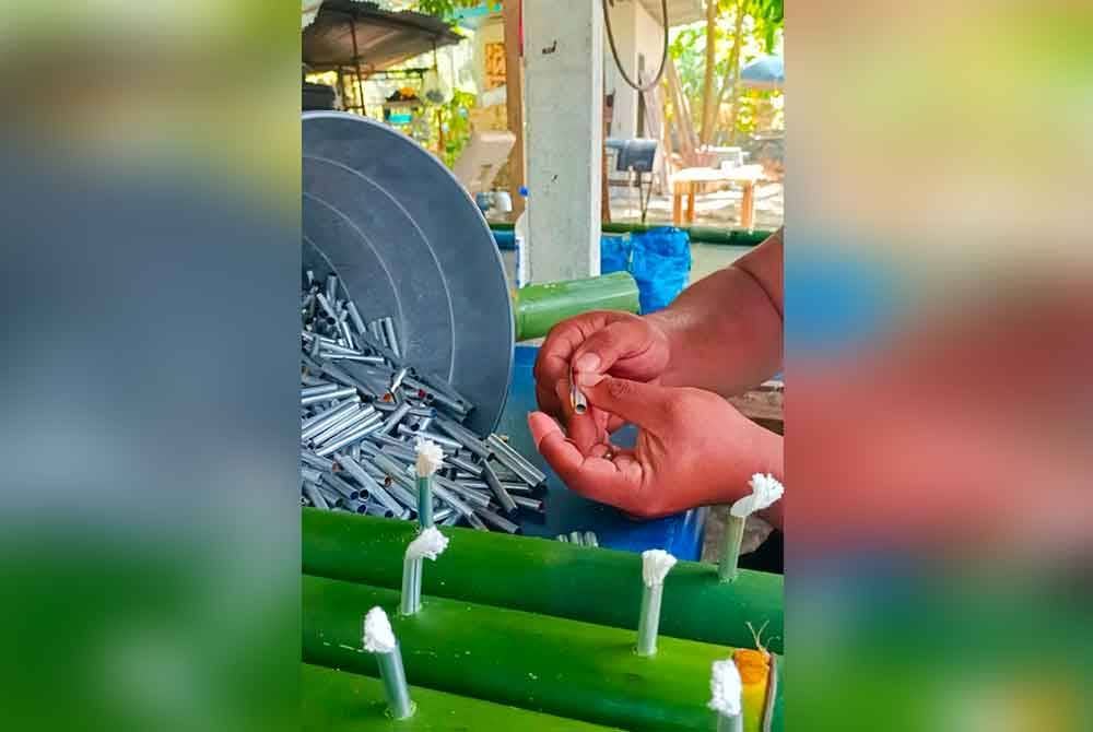 Kepingan aluminium dibuat sendiri menggunakan tin minuman terpakai, dipotong dan digulung sebelum dimasukkan sumbu.