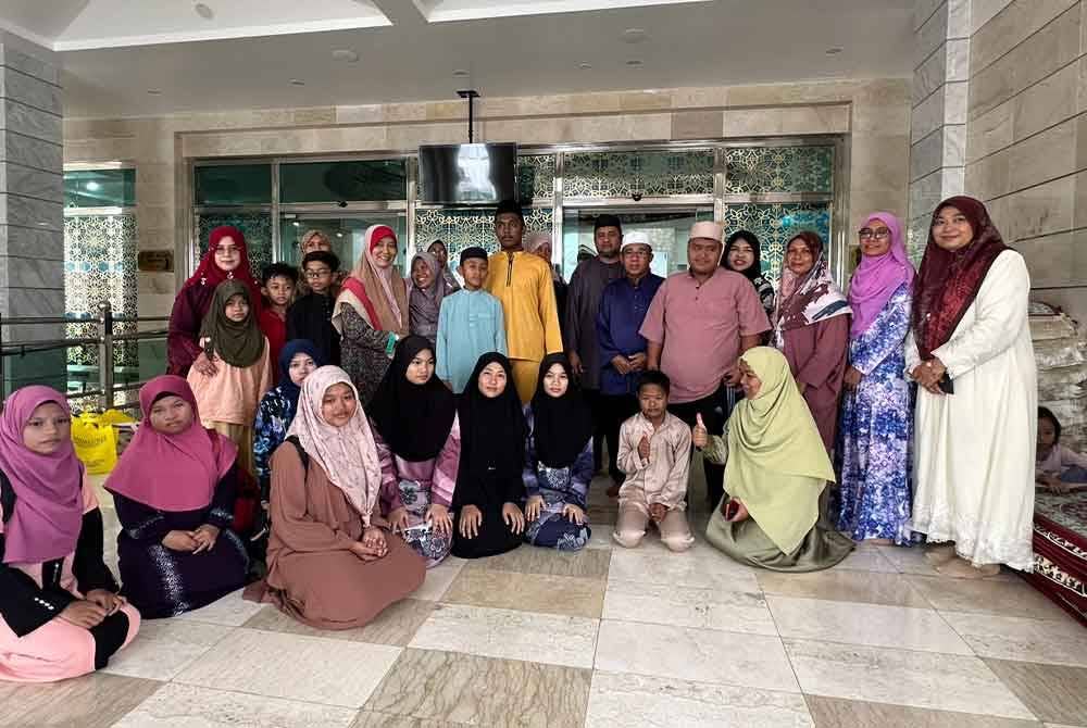 Penerima zakat bergambar di pintu masuk Masjid Imanul Fa'izin.