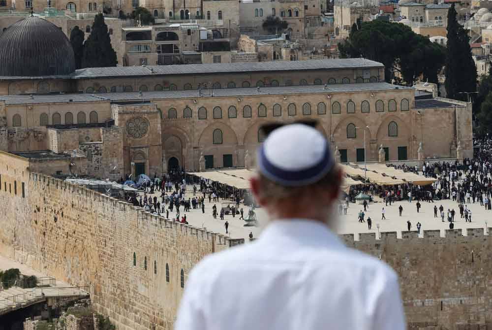 Seorang lelaki Israel bersembahyang di Bukit Zaitun menghadap pekarangan Masjid al-Aqsa pada Jumaat. Foto AFP