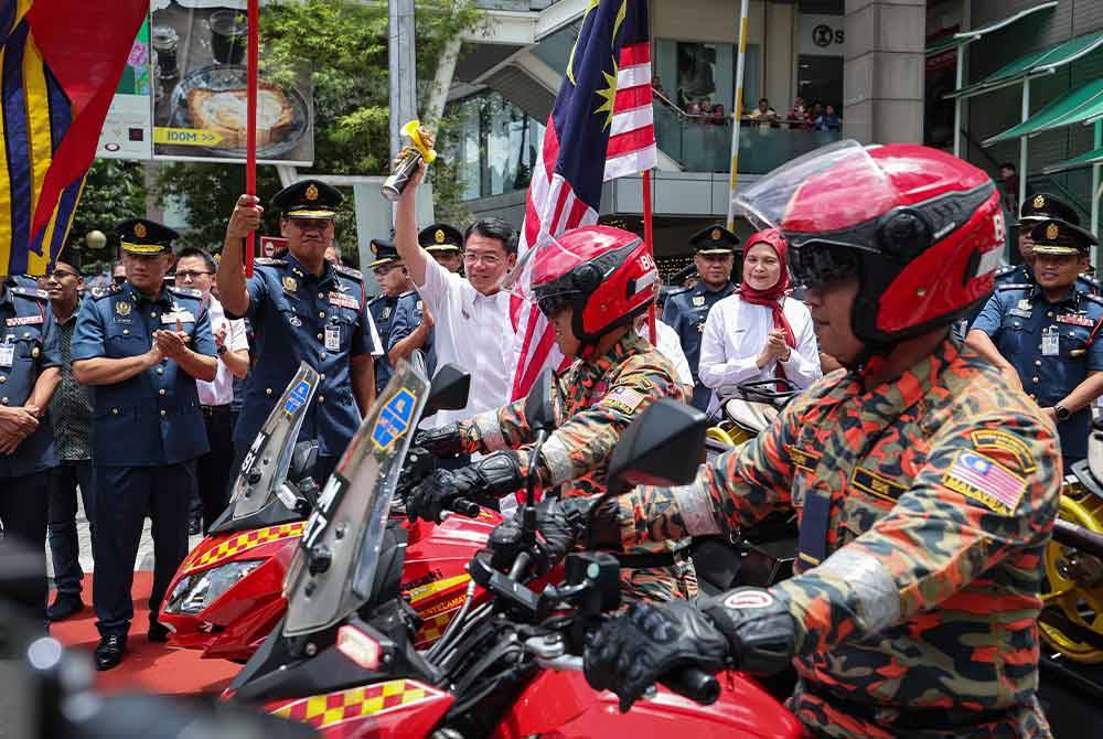 Kor Ming (depan, kanan) dan Nor Hisham (depan, kiri) melakukan flag off Ops Siaga selepas melancarkan Ops Siaga Raya Aidilfitri 2024 di sebuah pusat membeli belah pada Sabtu. Foto Bernama