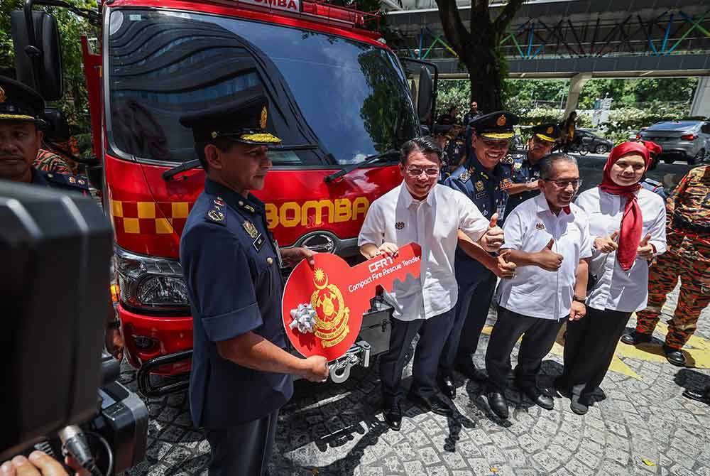 Kor Ming (dua dari kiri) menyerahkan replika kunci jentera Compact Fire Rescue Tender (CFRT) kepada Nor Hisham (kiri) selepas melancarkan Ops Siaga Raya Aidilfitri 2024 di sebuah pusat membeli belah pada Sabtu. Foto Bernama