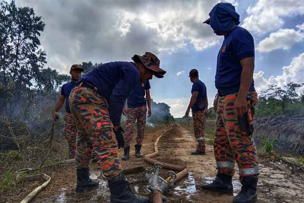Anggota bomba menggunakan teknik pancutan air terbuka menggunakan hos dari pam angkut untuk memadam kebakaran hutan tanah gambut di kawasan Jabatan Pertanian Inderapura di sini yang dilaporkan terbakar akibat cuaca panas sejak Khamis lalu.