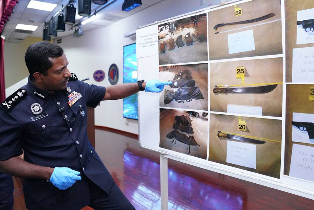 Hussein (kiri) menunjukkan antara senjata dan peralatan yang digunakan suspek yang ditembak mati di Persiaran Harmoni, Putra Heights pada awal pagi Sabtu.